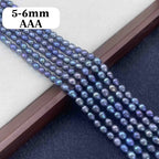 Multiple strands of iridescent freshwater pearl beads in a blue-purple color, displayed diagonally on a jewelry box. A white label in the top left corner reads '5-6mm AAA'.