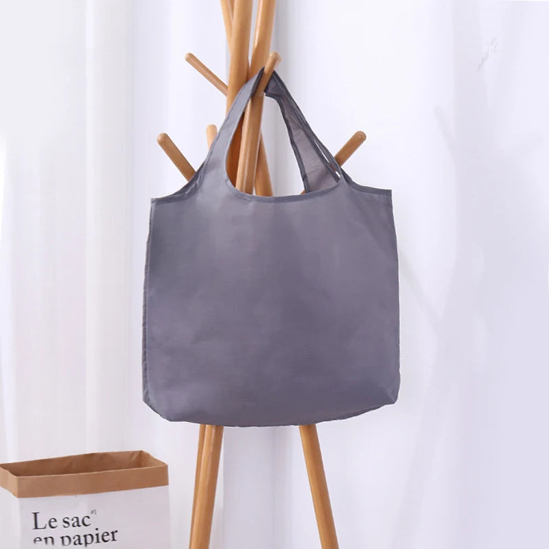 Gray tote bag with wooden handles on a light gray background