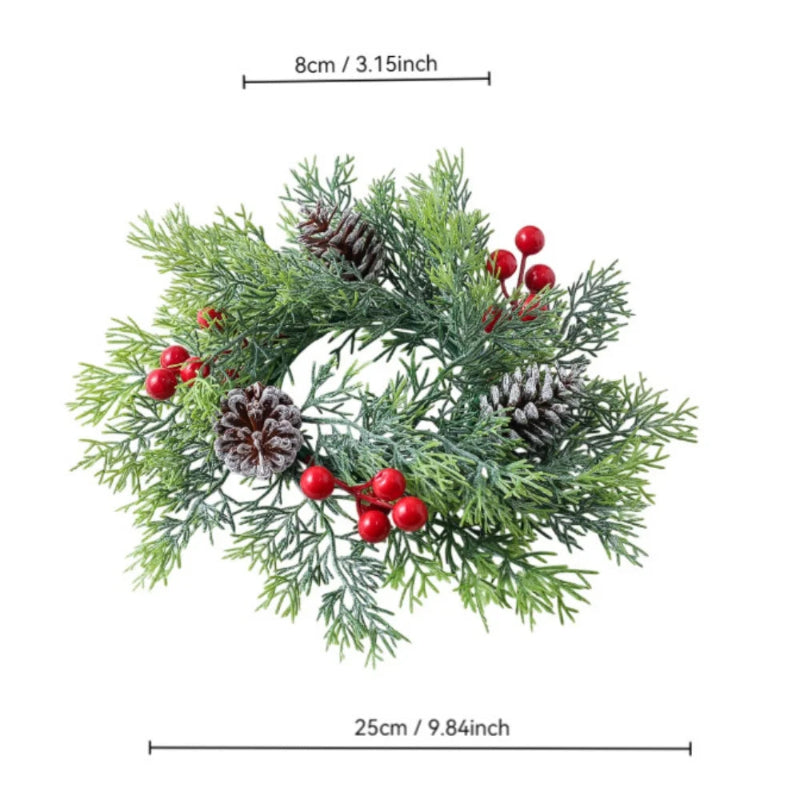 An artificial Christmas wreath with green frosted pine needles, brown pinecones, and red berries, shown with dimension lines indicating a width of 25cm (9.84 inches) and a height of 8cm (3.