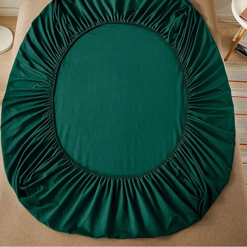 Green fitted sheet on a bed with 'vave' branding.