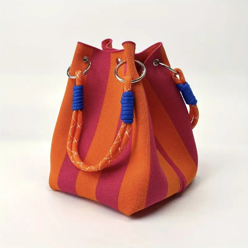 Orange and pink striped handbag with blue handles on a white background