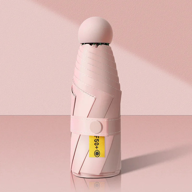 Pink umbrella folded and standing on a pink background