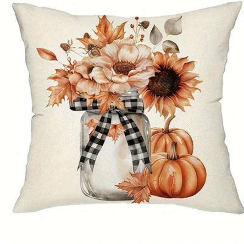 A square throw pillow with a warm autumn-themed print featuring sunflowers, pumpkins, and fall leaves in a glass jar vase with a black-and-white gingham ribbon, set against a cream-colored pillow base.
