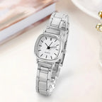 Silver watch with a white face on a light background