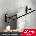 Black double rod towel rack with a towel hanging on a gray wall.