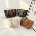 Four handbags in different colors and patterns on a white surface with a decorative frame in the background.