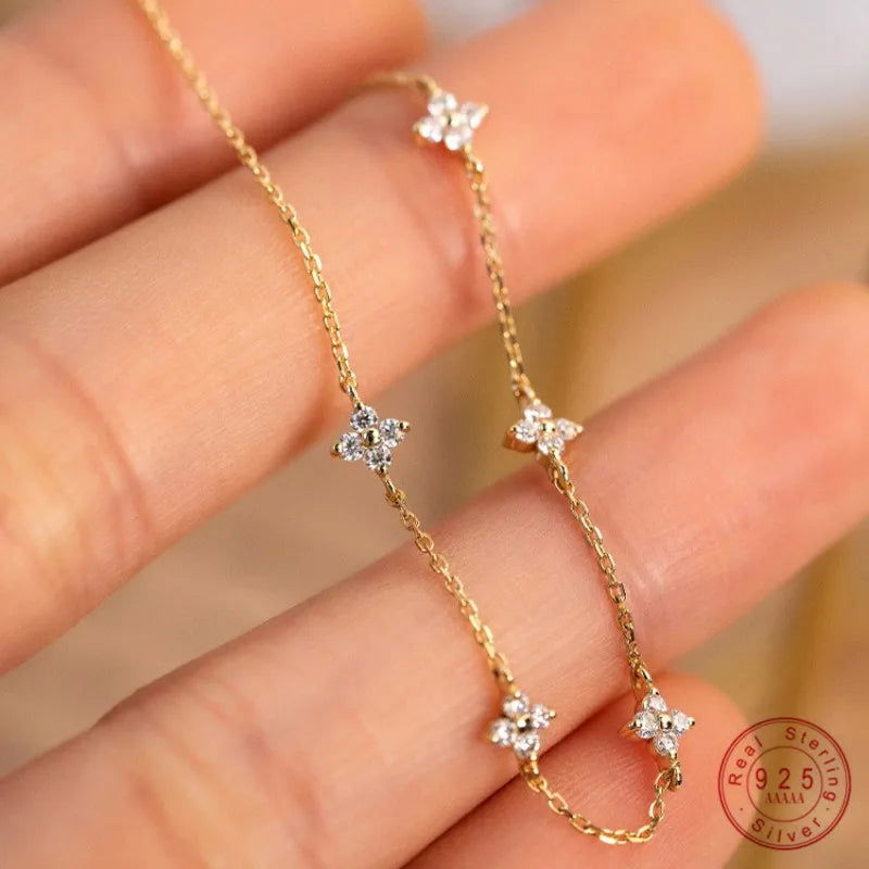 The EMESA HOME 925 Sterling Silver Plated 18k Gold Shiny Zircon Flower Bracelet is a delicate and elegant piece of jewelry designed to enhance a woman's style with its exquisite craftsmanship. - Emesa Home